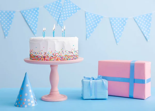 Tasty Birthday cake with gifts on table against color background — Stock Photo, Image