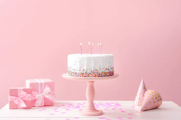 おいしい誕生日ケーキ色の背景にテーブルの上の贈り物 — ストック写真