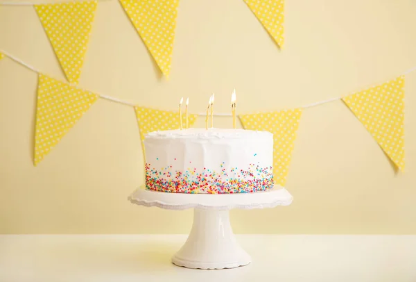 Smaczne tort urodzinowy na stole z kolorowym tłem — Zdjęcie stockowe
