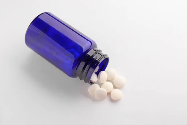 Frasco con pastillas sobre fondo blanco — Foto de Stock