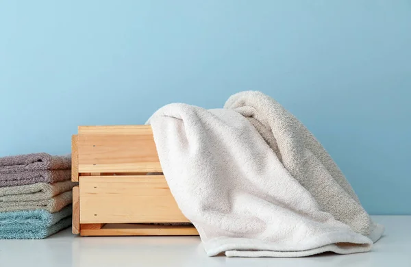 Toallas limpias suaves y caja de madera en la mesa — Foto de Stock