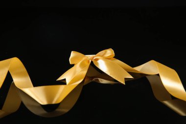 Koyu arkaplanda güzel fiyonklu altın kurdele