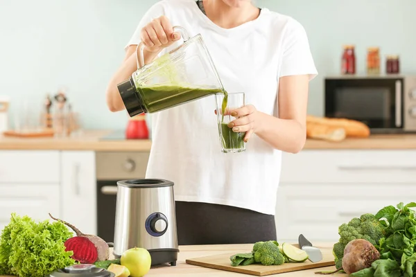Egészséges turmixot öntő nő üvegbe a konyhában — Stock Fotó