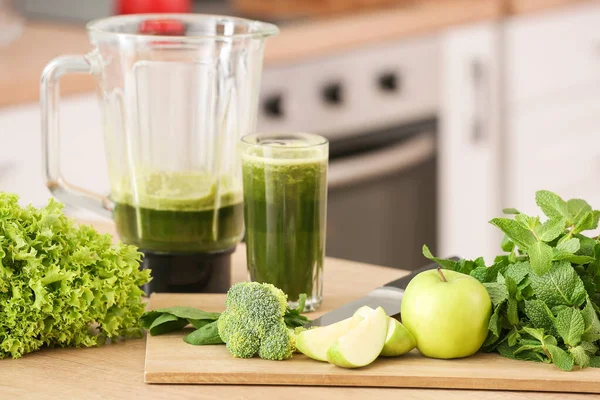 Glass and blender with healthy smoothie and ingredients on table in kitchen — Stock Photo, Image