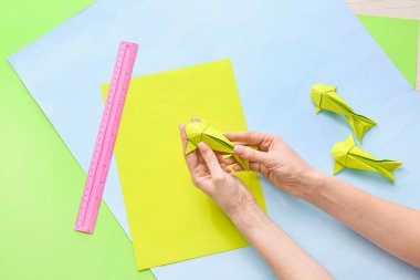 Masada origami balığı yapan kadın.