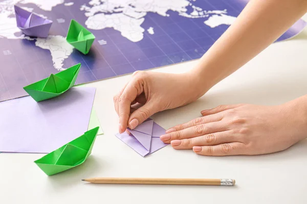 Woman making origami boat at table — Stock Photo, Image