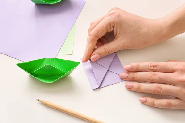 Woman making origami boat at table — Stock Photo, Image