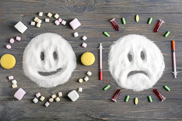 Samenstelling met gezichten van suiker en medicijnen op houten ondergrond — Stockfoto