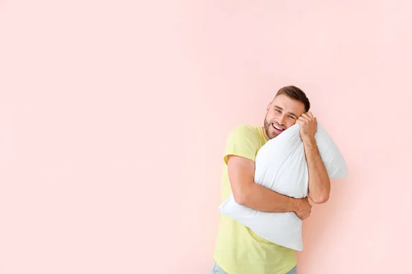 Молодой человек с подушкой на цветном фоне — стоковое фото