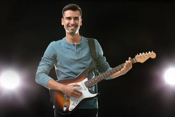 Handsome man playing guitar on stage — Stock Photo, Image