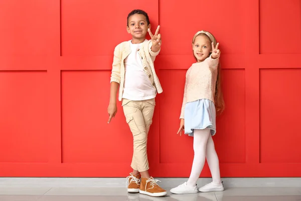Bambini alla moda in vestiti di autunno vicino a parete a colori — Foto Stock
