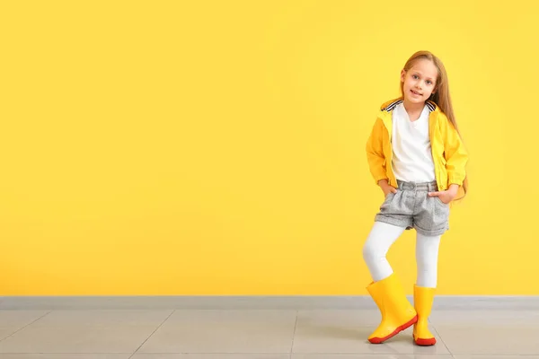 Renkli duvarın yanında sonbahar kıyafetleri içinde şık küçük bir kız. — Stok fotoğraf