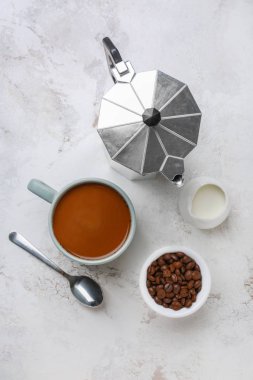 Sütlü bir fincan kahve ve beyaz arka planda demlik.