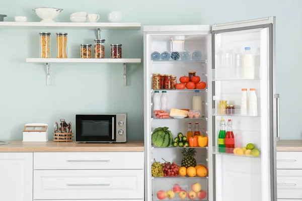 부엌에 제품 이 있는 큰 냉장고를 열라 — 스톡 사진