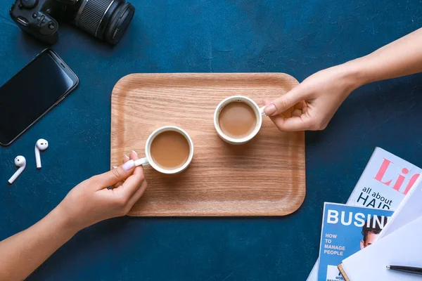 Female hands with cups of coffee on color background — Stock Photo, Image