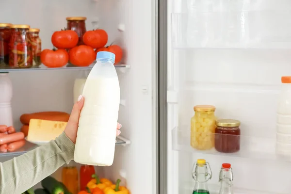 Frau holt Lebensmittel aus Kühlschrank — Stockfoto