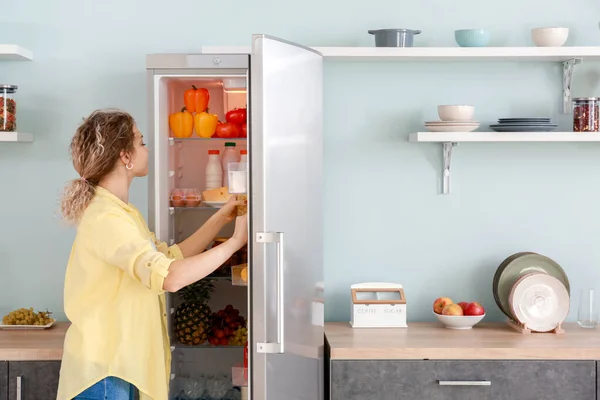 Mujer eligiendo comida en la nevera moderna en casa —  Fotos de Stock