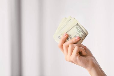 Arka planda dolar banknotları olan bir kadın.