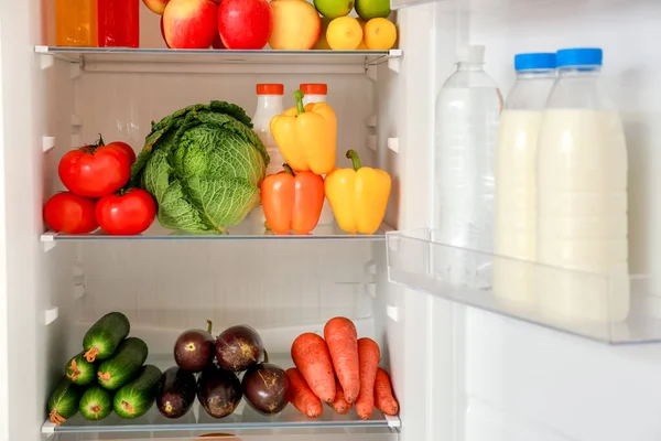 Различные продукты на полках в холодильнике — стоковое фото