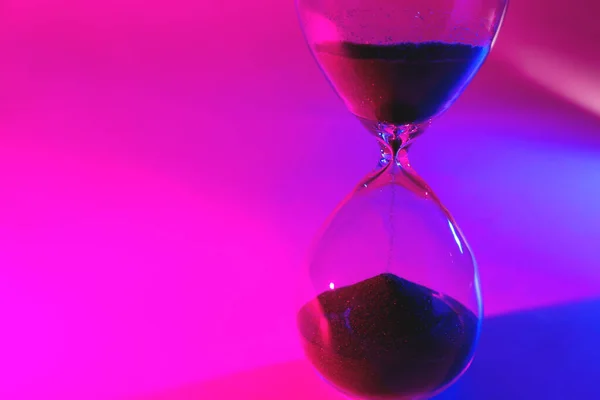 Кришталевий пісочний годинник на кольоровому фоні — стокове фото
