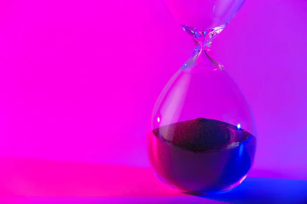 Кришталевий пісочний годинник на кольоровому фоні — стокове фото