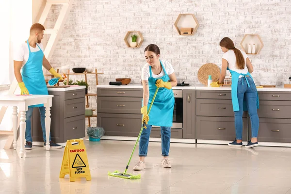 Team of janitors cleaning kitchen