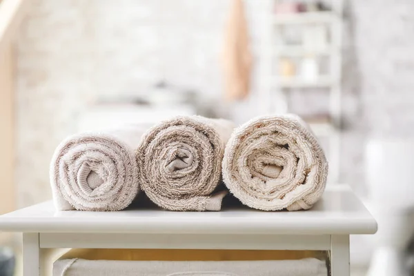 Rolled towels on table in bathroom