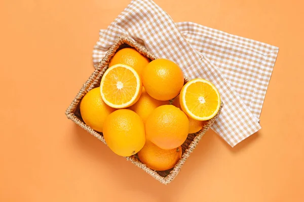 Basket with fresh oranges on color background — Stock Photo, Image