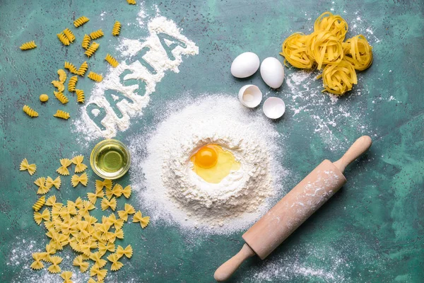 Különböző főzés nélküli tészta liszt, tojás és olaj színes háttér — Stock Fotó