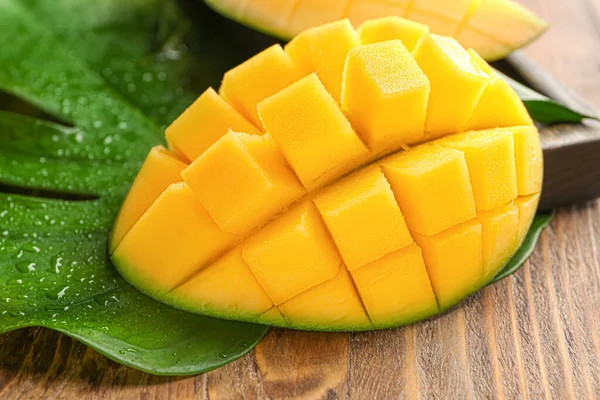Pieza de sabrosa fruta de mango sobre fondo de madera — Foto de Stock