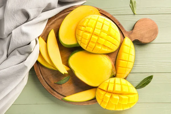 Board with cut mango fruit on table — Stock Photo, Image