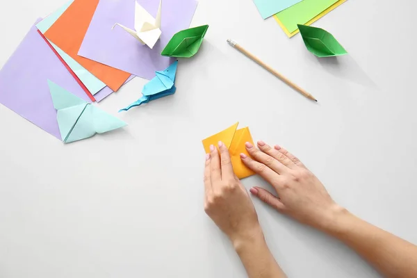 Frau bastelt Origami-Figuren am Tisch — Stockfoto
