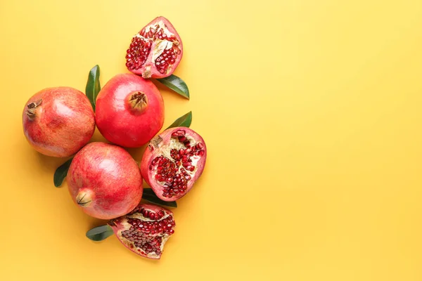 Ripe juicy pomegranates on color background — Stock Photo, Image