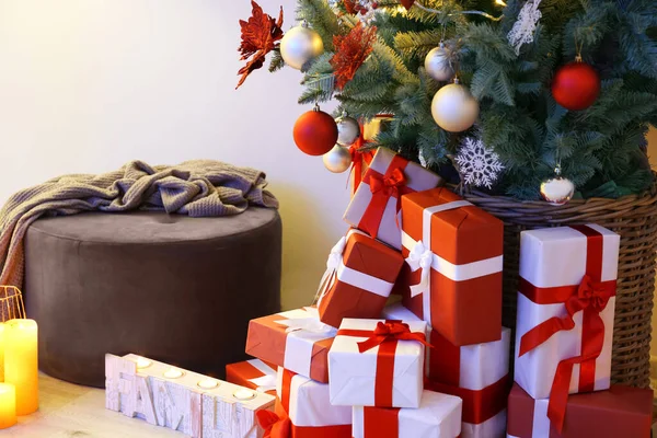 Gift boxes under decorated Christmas tree in room — Stock Photo, Image