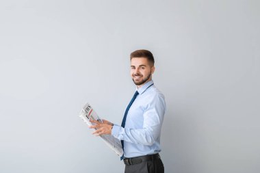 Arka planda gazetesi olan yakışıklı bir iş adamı.