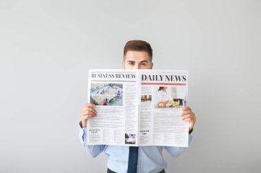 Arka planda gazetesi olan yakışıklı bir iş adamı.