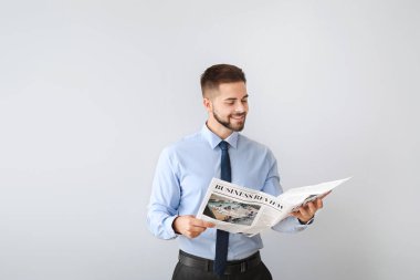 Arka planda gazetesi olan yakışıklı bir iş adamı.