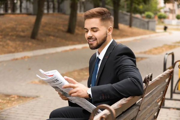 Handsome businessman with newspaper outdoors — Stock Photo, Image