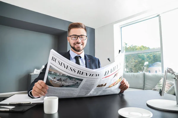 Hombre de negocios guapo leyendo el periódico en la oficina — Foto de Stock