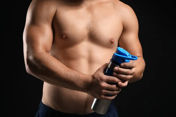 Όμορφος αρσενικός bodybuilder με πρωτεϊνικό κούνημα σε σκούρο φόντο — Φωτογραφία Αρχείου