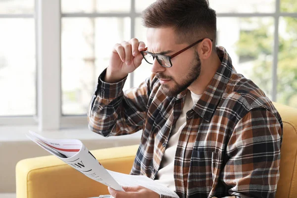 Besorgter Mann liest Zeitung zu Hause — Stockfoto