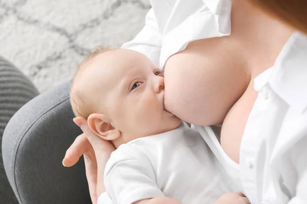 Jovem mulher amamentando seu bebê em casa, close-up — Fotografia de Stock