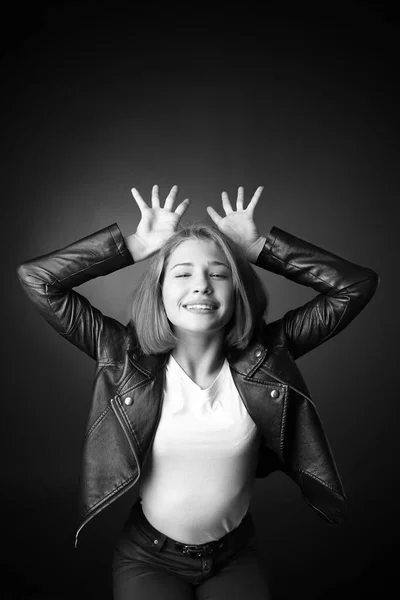 Retrato preto e branco de menina adolescente feliz no fundo escuro — Fotografia de Stock