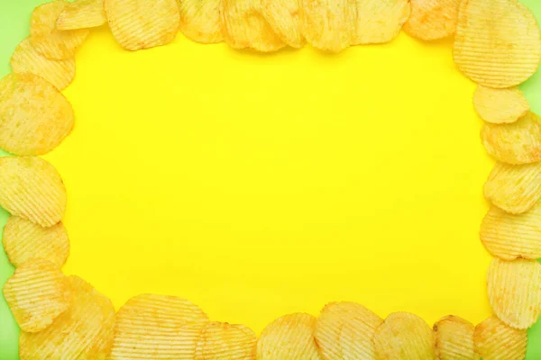 Frame made of tasty potato chips on color background — Stock Photo, Image