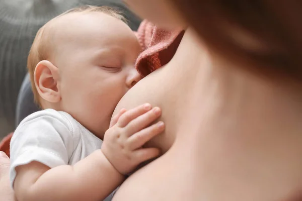 Mujer joven amamantando a su bebé en casa, primer plano —  Fotos de Stock