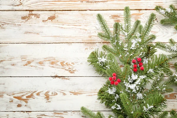 Beyaz ahşap zemin üzerinde kar olan güzel Noel ağacı dalları — Stok fotoğraf