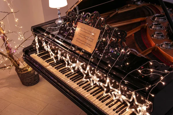 Пианино с гирляндой в номере — стоковое фото