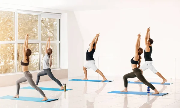 Gruppe von Menschen, die Yoga in der Turnhalle praktizieren — Stockfoto