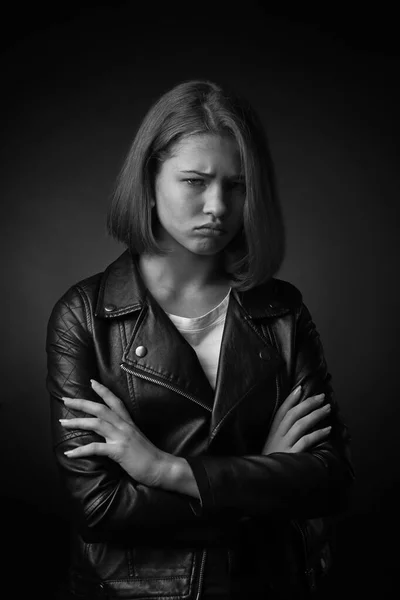 Black and white portrait of offended teenage girl on dark background — Stock Photo, Image