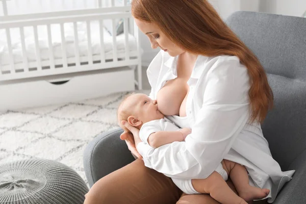 Mladá žena kojit své dítě doma — Stock fotografie